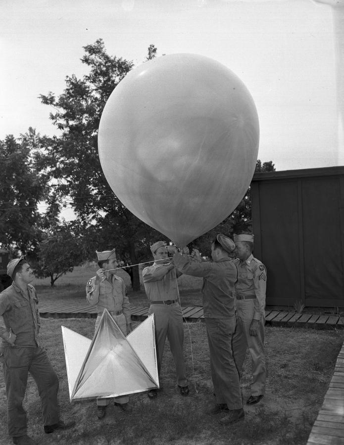 Пять летчиков демонстрируют радарное устройство, прикрепленное к метеорологическому шару на военно-воздушной базе Форт-Уэрта 7 июля 1947 года, через пять дней после инцидента в Розуэлле, Нью-Мексико, НЛО
